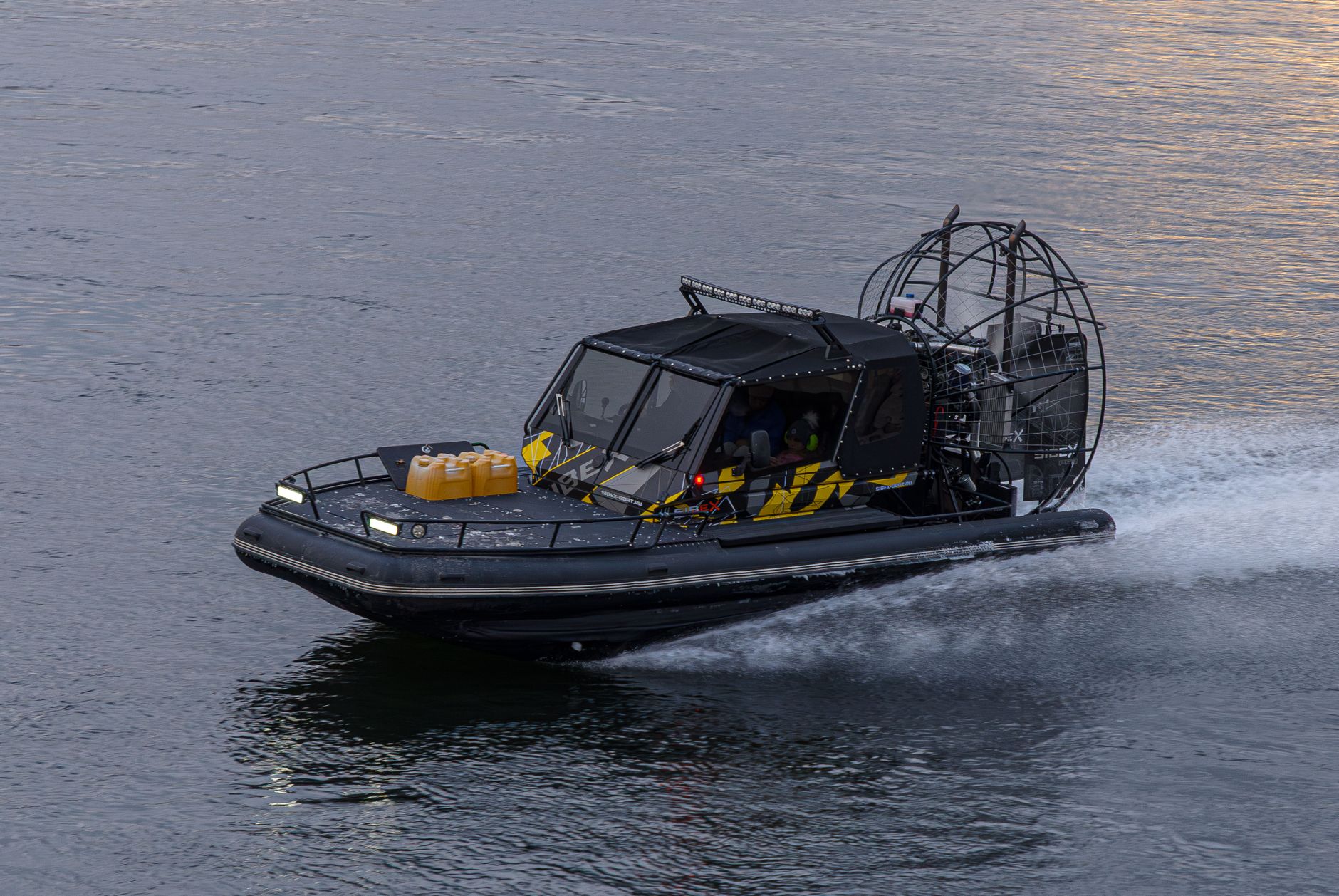 A modern airboat speeds across calm waters, showcasing advanced design and engineering.
